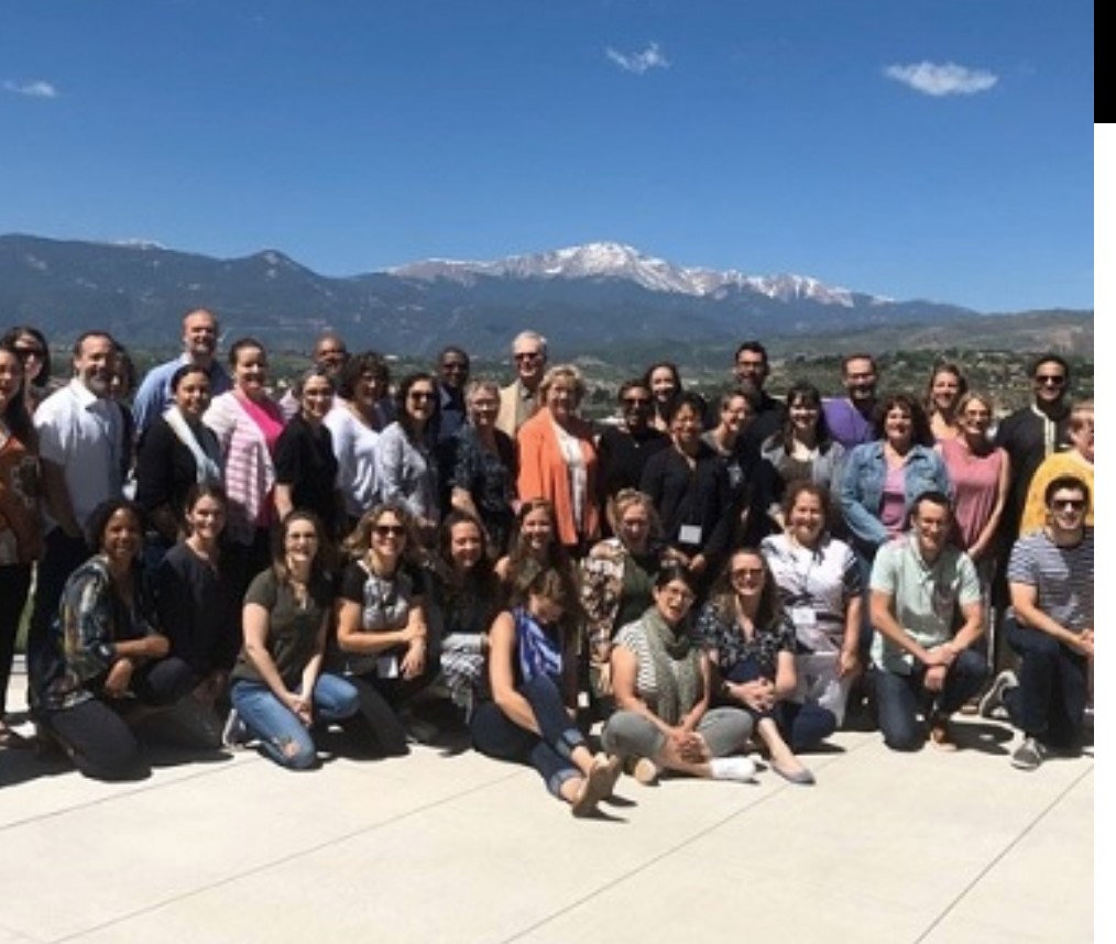 people posing for photo in front of mountains